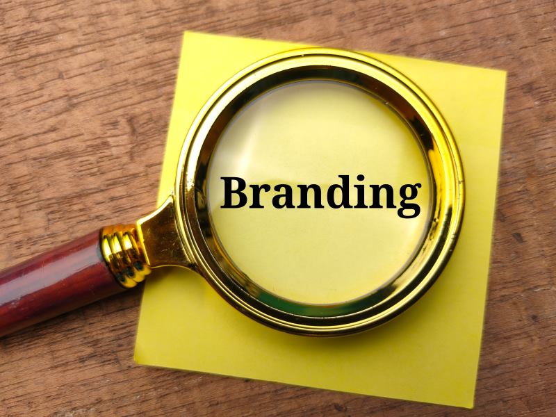 A magnifying glass focused on the word "Branding," symbolizing the importance of focusing on promoting your brand at large-scale events.